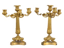 Coppia di candelieri a quattro fiamme in bronzo dorato con fusto scanalato e piedi ferini